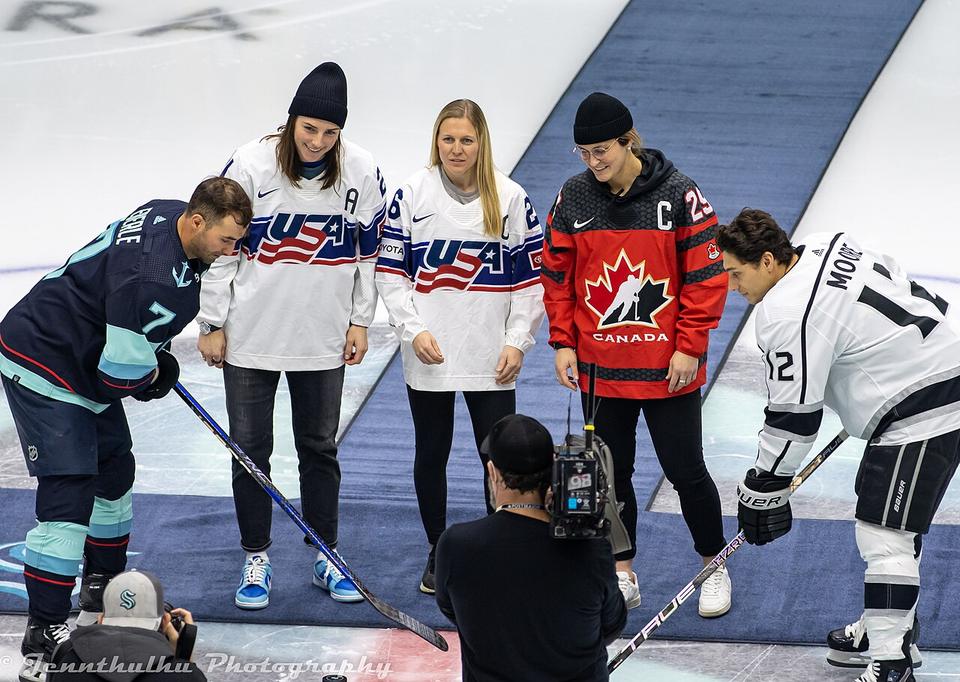 Team USA players Hilary Knight and Kendall Coyne Schofield, and Team Canada captain Marie-Philip Poulin participate in the ceremonial opening faceoff in Seattle