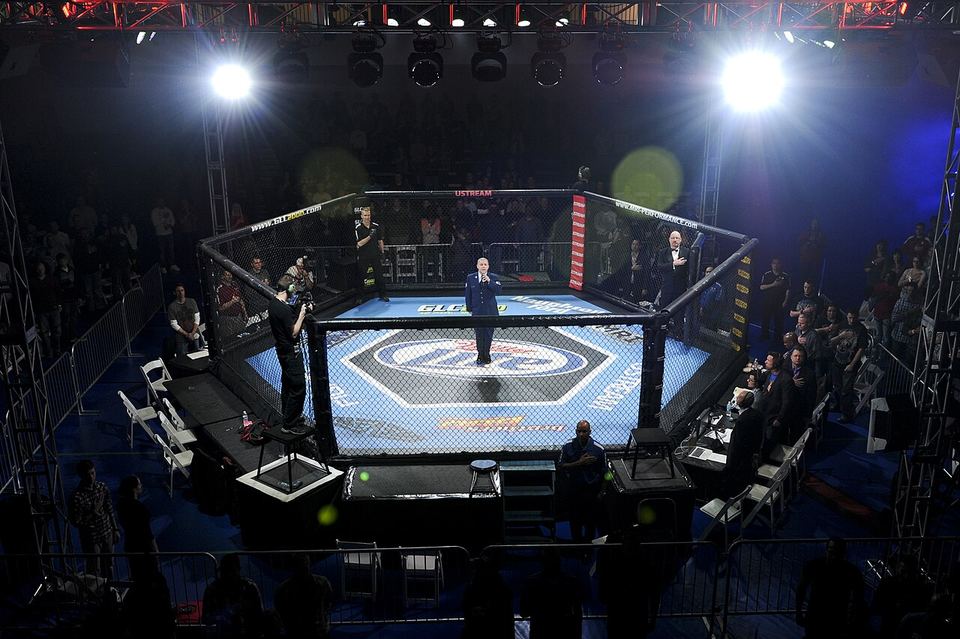Staff Sgt. Zachery Rayburn, 460th Space Communications Squadron radio frequency system crew member, sings the national anthem during the Buckley MMA Fight Night